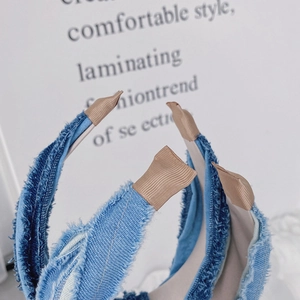 Gros plan d'un serre-tête en jean avec bords effilochés et texture de tissu doux