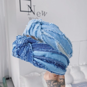 Détail de serre-têtes en jean bleu clair et foncé avec nœud et bords effilochés