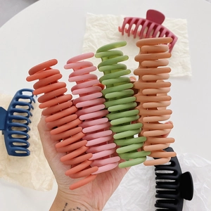 Detail of matte large shark hair clips in assorted vibrant colors with wavy grip