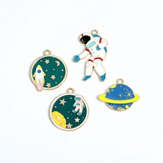 Detail of space enamel pin set with astronaut, rocket and Saturn on white background