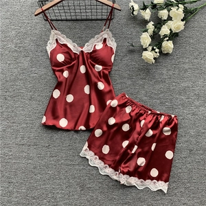 Detail of satin pajama set with white lace trim and polka dot pattern on burgundy fabric