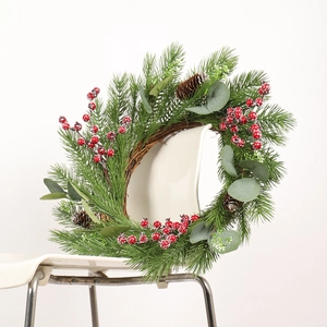 Artificial Christmas wreath with red berries, pine cones and eucalyptus on a chair