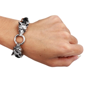 Men's braided leather bracelet featuring dual silver wolf heads with a steel ring clasp