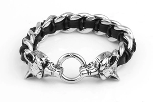 Macro view of twin wolf heads on braided leather and stainless steel bracelet