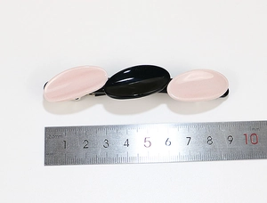 Macro view showing 8.5-9cm length of pink and black acetate geometric hair clip