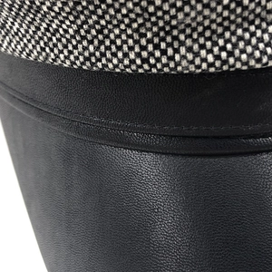 Detailed macro view of the black leather brim and plaid tweed fabric texture