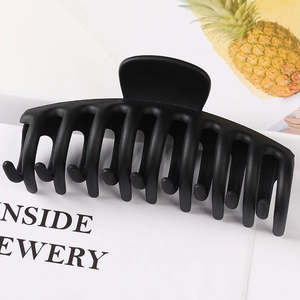 Close-up of matte black large claw clip with sturdy multi-tooth design on display board