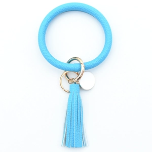 Detail of bright blue PU leather wristlet keychain with tassel and gold-tone metal hardware