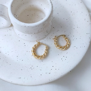 Minimalist 14K gold plated twisted hoop earrings for women on a ceramic plate