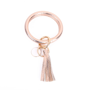 Detail view of rose gold PU leather bracelet keychain with tassel and metal ring