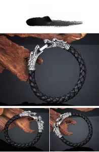 Macro shot of dual dragon head charms on a black braided leather bracelet for men