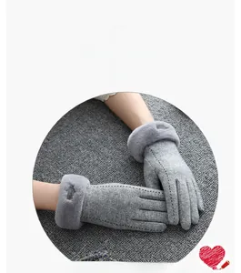 Detail of grey suede winter gloves with plush faux fur trim and stitched back design