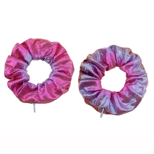 Close-up of two pink-purple gradient hair scrunchies with metallic luster texture