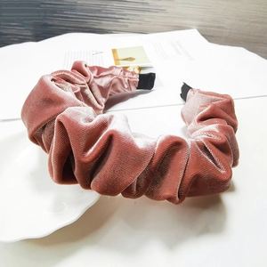 Detail of pink velvet pleated headband with soft texture and vintage ruched design