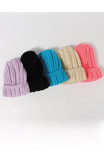Détail de bonnets d'hiver en grosse maille de plusieurs couleurs avec motif à côtes