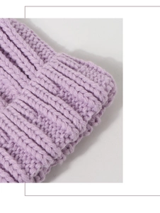 Gros plan sur la texture en maille côtelée lavande d'un bonnet d'hiver épais