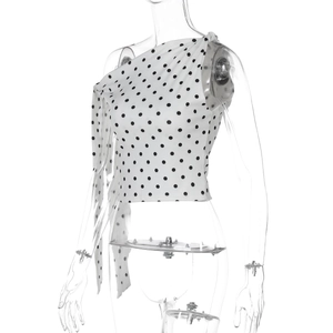 Close-up of asymmetrical polka dot crop top with ruched shoulder detail for women