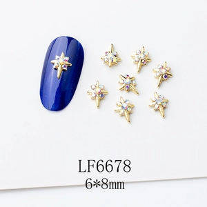 Vue macro de bijoux d'ongles croix dorée 6x8mm avec strass sur ongle bleu