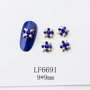 Détail de bijoux d'ongles fleur 9mm avec strass bleu saphir et base en alliage doré