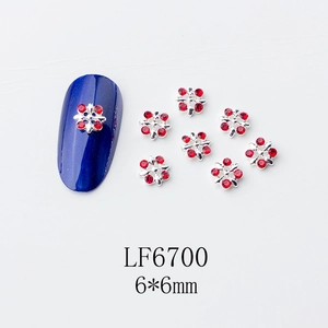 Détail macro de charmes d'ongles flocons rouges avec base en alliage et strass
