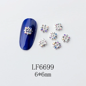 Détail macro du bijou d'ongle flocon de 6x6mm avec base argentée et strass brillants