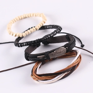 Multilayer leather bracelet set with wing charm and wooden beads on white background