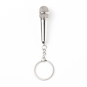 Polished silver metal microphone keychain creative gift on white background