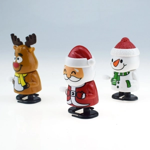 Close-up of wind-up Christmas toys including Santa, reindeer, and snowman on white background