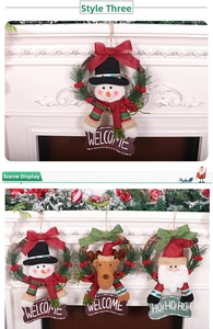 Close-up of Christmas wreath with plush reindeer and Welcome sign on white fireplace