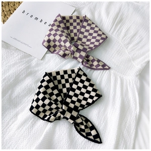 Close-up of checkered knit scarves in purple and black with soft woven texture