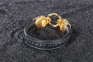 Detail of black woven leather bracelet with golden leopard head clasp closure