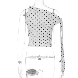 Rear view of one-shoulder polka dot crop top featuring a long decorative sash on the side