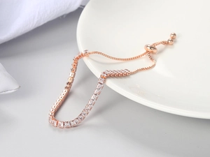 Detail of rose gold adjustable bracelet featuring square-cut white zircon and slide clasp