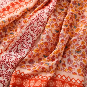 Detailed close-up of bohemian floral print and woven texture on a cotton linen shawl