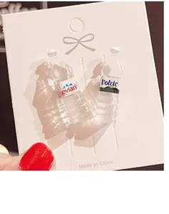 Macro shot of creative mini resin water bottle earrings on a white display card
