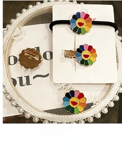 Detailed set of colorful sunflower hair accessories and brooch on a pearl tray