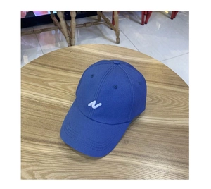 Détail de la broderie de la lettre N blanche sur la casquette de baseball bleue