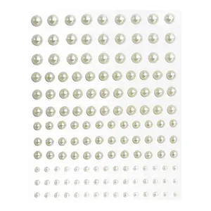 Macro detail of multi-size gradient ivory pearl adhesive stickers for face and DIY crafts