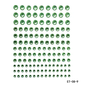Macro detail of green acrylic rhinestone face stickers in 12 rows of varying sizes