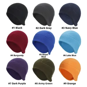 Detail view of nine fleece thermal beanies with ear flaps in various solid colors