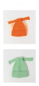 Detailed view of knitted baby hats with long bow ties in orange and light green colors