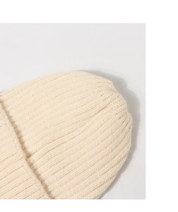 Detailed close-up of ivory ribbed knit texture and stitching on top of the kids beanie