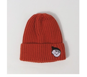 Detailed view of an orange knit beanie featuring a cartoon boy embroidery on the folded cuff