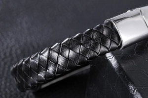 Macro shot of premium black woven leather texture and polished steel metal clasp