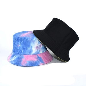 Detail of tie-dye and black corduroy bucket hats showing high-quality stitching and fabric texture