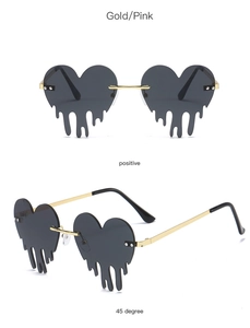 Detail view of heart-shaped melting rimless sunglasses with gold frames and dark lenses