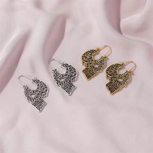 Vintage gothic hollow-out skull earrings in gold and silver finish on satin background