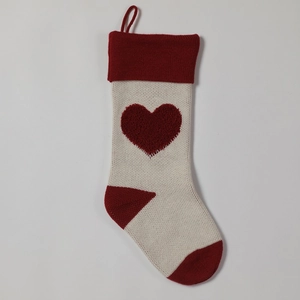 Close-up of knitted Christmas stocking with 3D red heart and loop for festive hanging