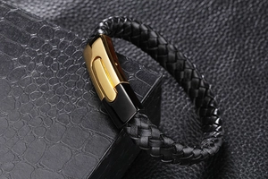 Détail du bracelet en cuir tressé noir avec fermoir magnétique en métal doré et noir