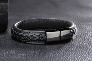 Détail d'un bracelet en cuir tressé noir avec fermoir magnétique en métal poli